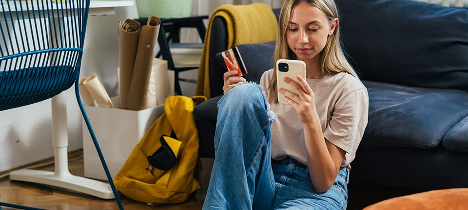 Ung pige med mobil og betalingskort