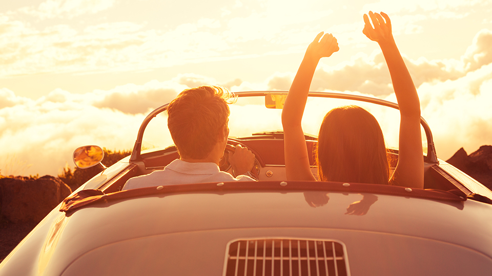 Ungt par ser solnedgang i bilen