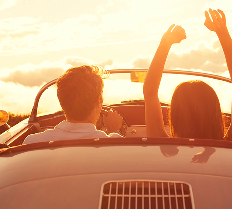 Ungt par ser solnedgang i bilen